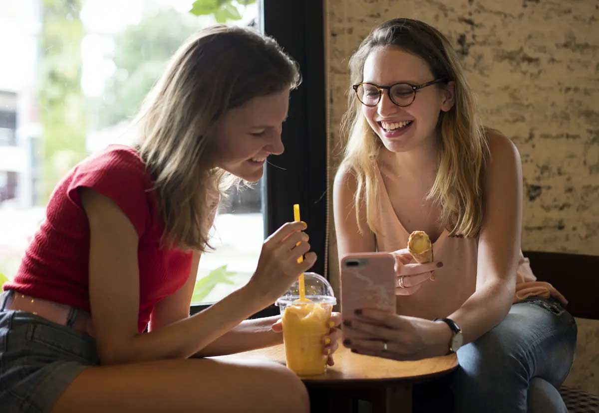 Two students sitting at table enjoying a snack